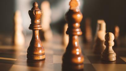 close up of game pieces on a chess board symbolizing strategizing a success plan