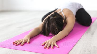 Woman doing yoga on a pink yoga mat