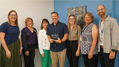 Institutional Integrity and Compliance Office staff holding the award