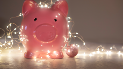 A piggybank wrapped in Christmas lights