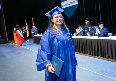 Rheanan Heller walking across the stage at commencement