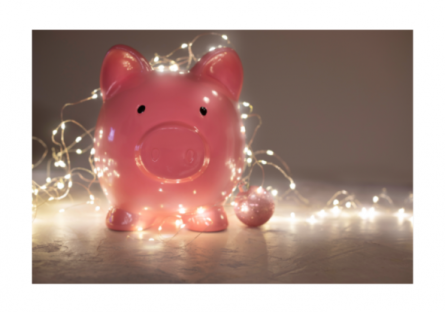 A piggybank wrapped in Christmas lights