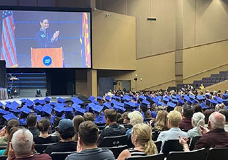 Attendees and HSE graduates listen to a speaker at the podium during the graduation ceremony