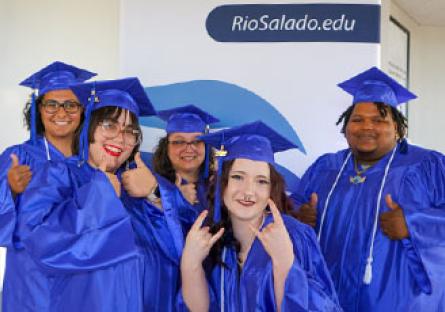 HSE graduates celebrate in front of a Rio Salado College banner
