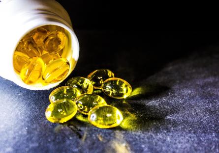 Omega-3 supplements spilling out of pill bottle